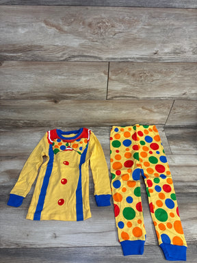 Flat lay of NEW Joyond 2pc pajama set in yellow showcasing clown costume print top and multicolor polka dot pants on wood plank floor