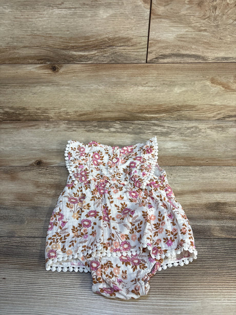 Top-down view of ivory Daisy Fuentes floral bodysuit dress 18M with pink and brown flowers, lace trim and attached bloomers on wood floor
