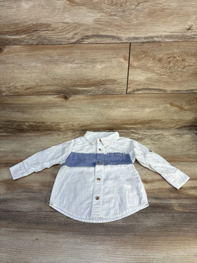 White long sleeve kids shirt with blue stripe and buttons, laid on wood surface