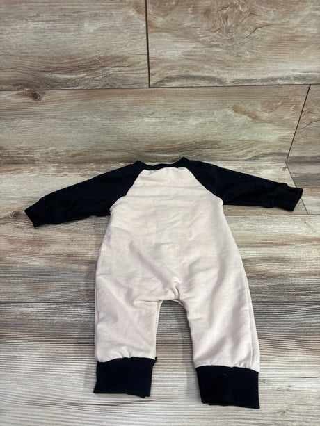 Lamuusaa Mama’s Little Boo coverall with a light-colored body, black raglan sleeves and cuffs on a wood surface