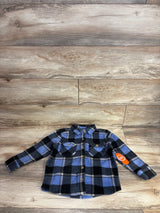 Blue and black plaid flannel long sleeve toddler shirt with front pockets on wood background