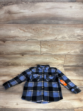 Blue and black plaid flannel long sleeve toddler shirt with front pockets on wood background