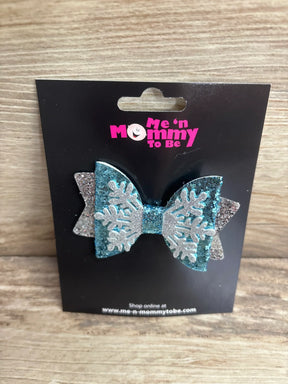 Glittery blue and silver snowflake hair bow for kids, festive winter accessory on black card