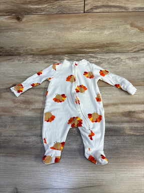 White baby onesie with long sleeves and footies featuring orange and red turkey prints on wooden floor