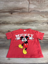 Red toddler T-shirt with Mickey Mouse graphic and text on wood floor background