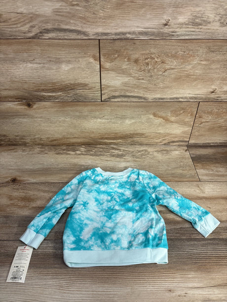 Baby long sleeve tie-dye blue and white shirt on wooden background with clothing tag attached