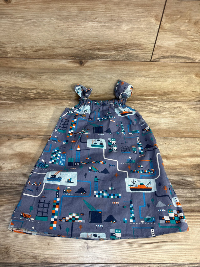 Gray baby dress with city map print, construction trucks, boats, and buildings on wood floor