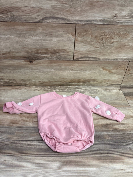 Front view of pink UAMVSH bubble romper, size 9 to 12 months, with white accents and snap closures on wood-look flooring