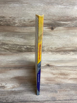 Side view of a thin children's book titled 'Polka Dots and Tater Tots' standing on a wooden surface