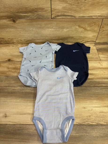 Top view of Nike 3-pack bodysuits in size 9 months showcasing gray printed, navy, and blue-gray striped designs