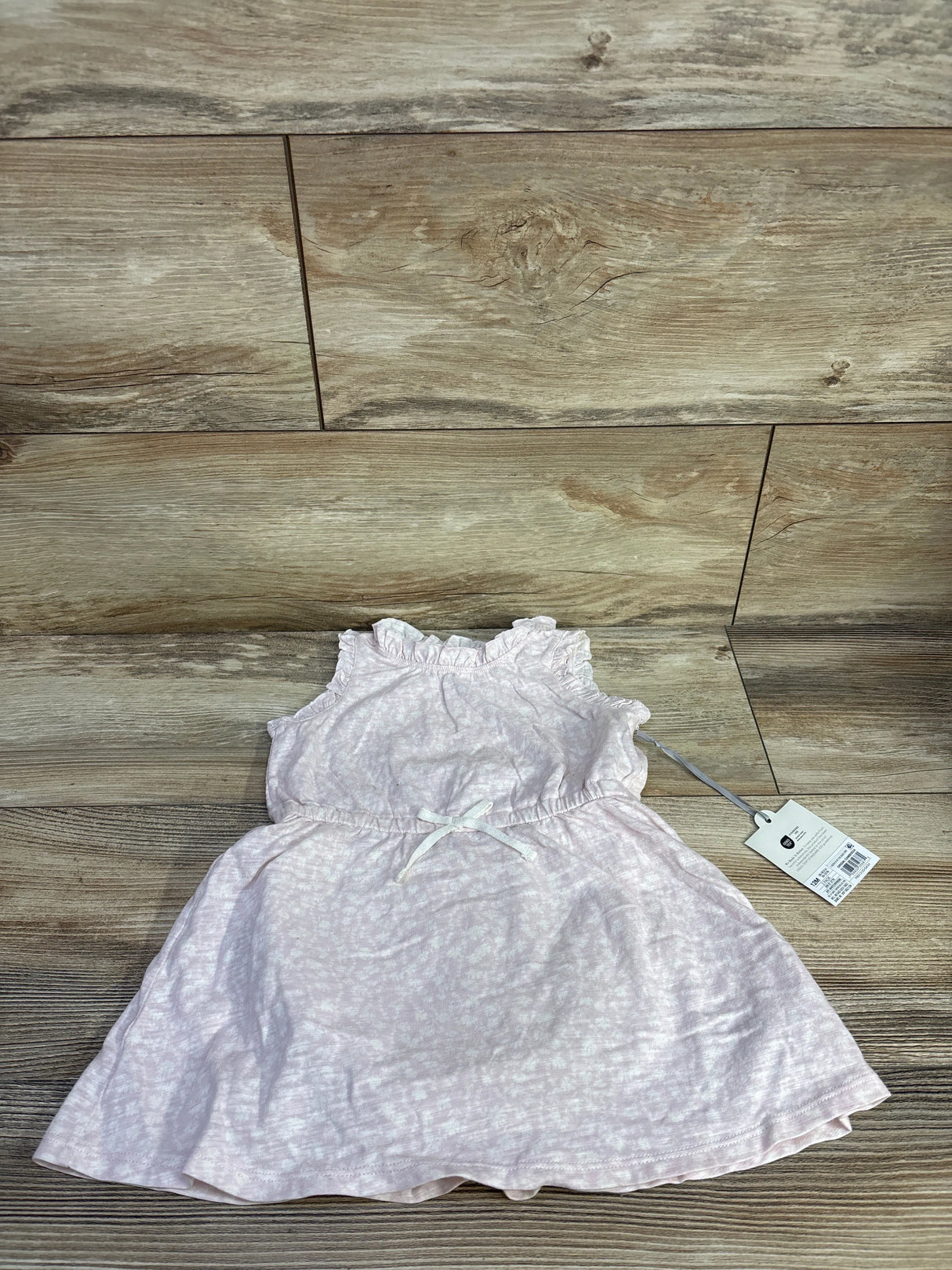 Flat lay of pink Cloud Island tank dress and matching bloomers showing ruffled neckline and waist bow on wood floor background