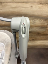 Close-up of Graco Slim Spaces Compact Baby Swing in Reign showcasing the control panel and swing frame with a wood background