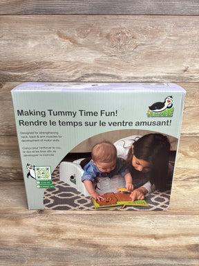 Tummy time support wedge for babies, with baby and child reading on a patterned rug