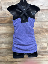 Front view of purple maternity cami with cross-back adjustable straps and ruched sides on black mannequin, wood background
