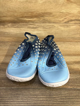 Front view of Fires Barefoot quick-dry water shoes, light blue, perforated upper, navy elastic laces, white sole on wood