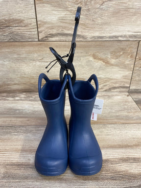 Front view of BEARPAW EVA toddler navy rain boots showcasing pull on handles with wood plank background