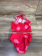 Flat lay of toddler two-piece red strawberry swimsuit size 12 months showing strawberry print and crisscross straps on wood
