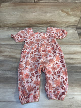 Pink floral baby romper with puff sleeves and snap leg closure on wood background