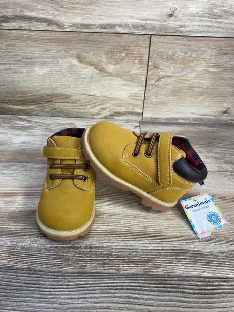 Three-quarter view of Garanimals toddler boots in mustard brown with velcro strap, elastic laces and plaid lining on wood background