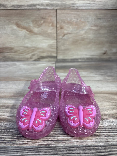 Side and top view of pink Old Navy jelly Mary Jane flats showing butterfly decoration and strap on white background, size 5C