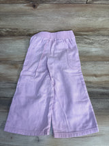 Light purple kids shorts with elastic waist and side pockets, laid on wood floor