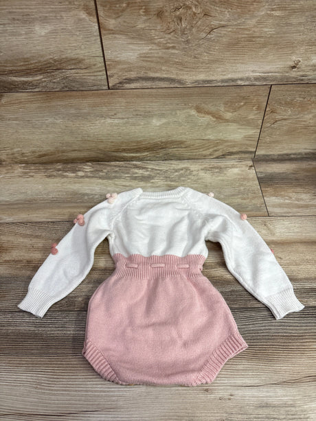 Front view of ZZLBUF Pom-Pom Heart Knit Bubble Romper with white knit top and pink bottom on a wood floor
