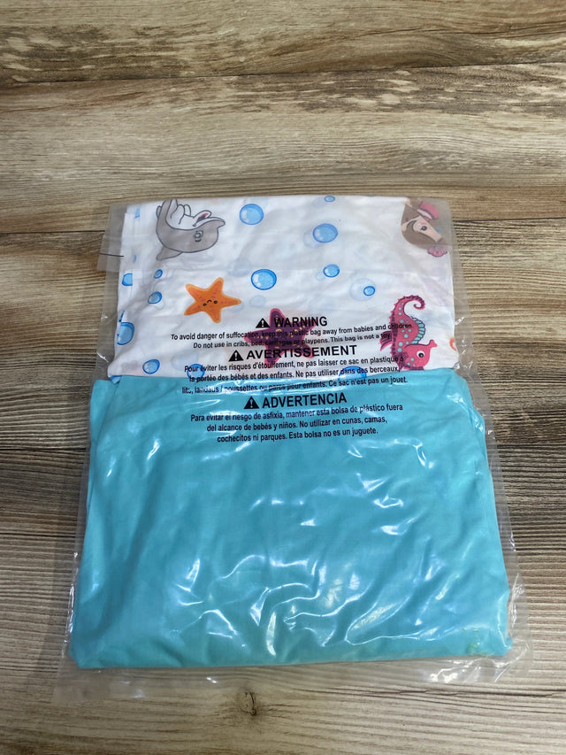 Flat lay of NEW Everyday Kids 2pk Fitted Crib Sheets in teal and sea creature print in original packaging on wood plank floor