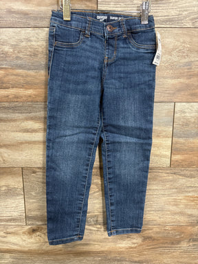 Dark wash kids skinny jeans with front pockets displayed on wooden background