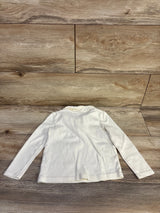 Back flat lay of Gymboree cream long sleeve toddler top showing ruffled Peter Pan collar on wood floor background