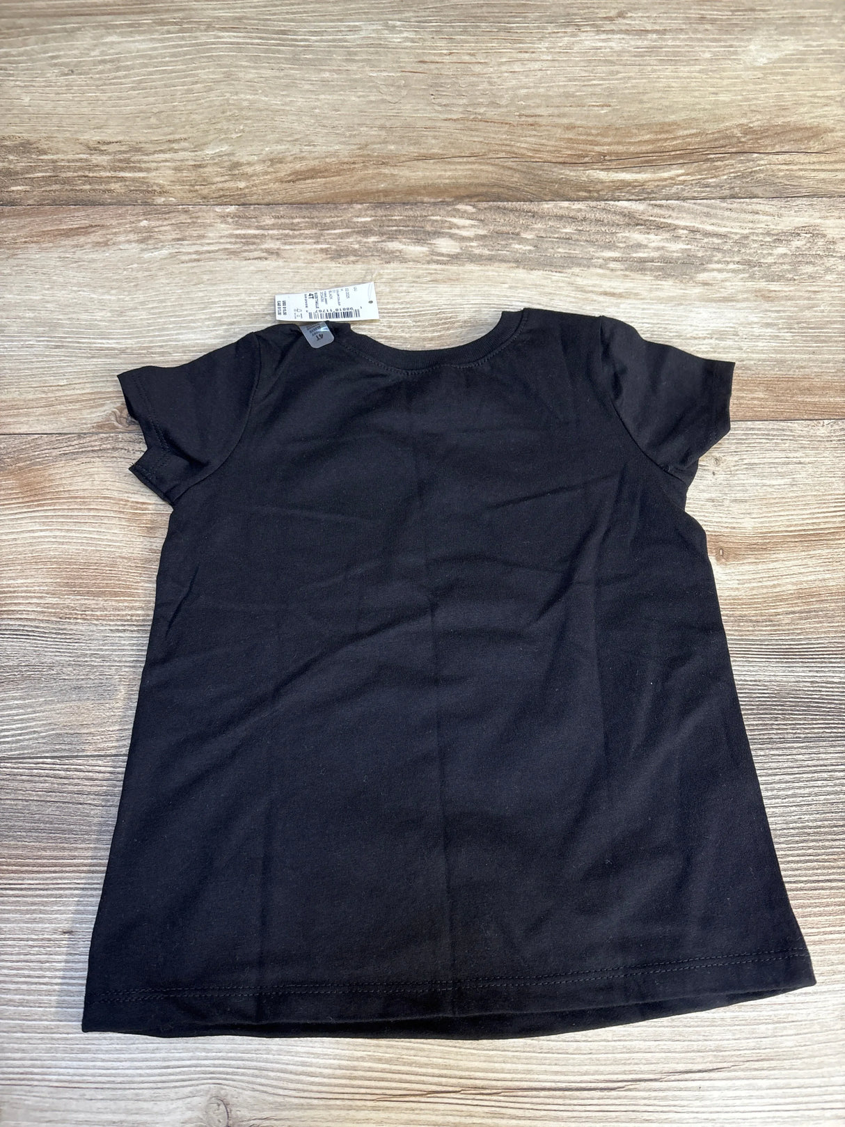Black kids t-shirt on wooden surface, resale clothing for children