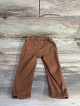 Rear view of brown H and M twill toddler trousers size 12 months showing elastic waistband and back patch pockets on wood floor background