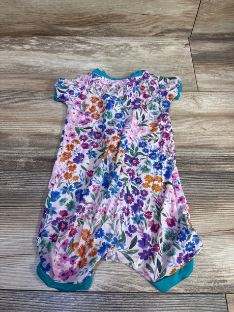 Flat lay of Little Sleepies pink floral bamboo shorty zippy sleeper with teal trim on a wood floor
