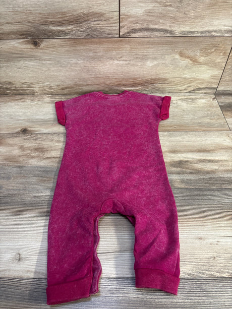 Back view of Disney Baby Minnie Mouse magenta 12m jumpsuit with short sleeves, cuffed legs, washed fabric on wood floor
