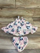 Flat lay of Disney Baby gauze dress and bloomers showing pink and navy Minnie Mouse print on wood background