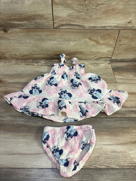 Flat lay of Disney Baby gauze dress and bloomers showing pink and navy Minnie Mouse print on wood background