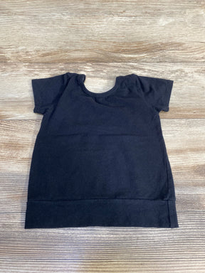 Flat-lay of black short-sleeve toddler shirt showing crew neckline, short sleeves, and wide hem on light wood background