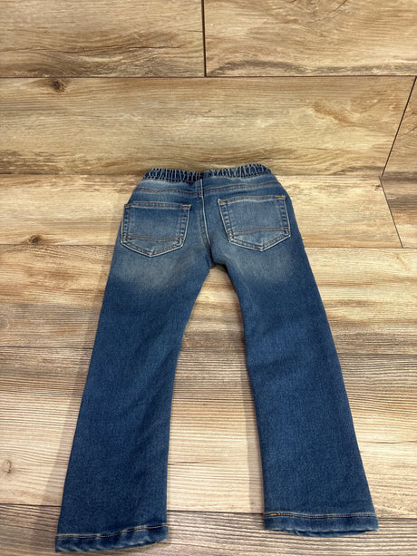 Back view of Cat & Jack blue drawstring skinny jeans for toddlers size 3T on wood background