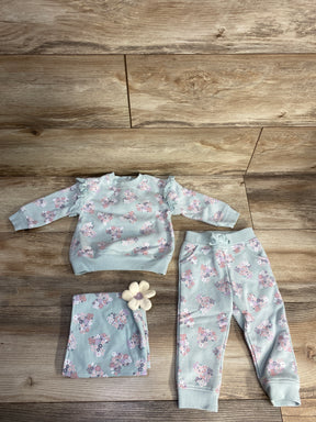 Baby girl floral print sweatshirt and pants set in pastel colors with matching floral blanket on wooden floor