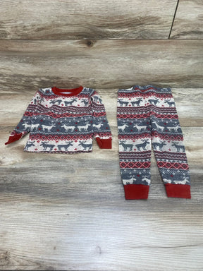 Flat lay of Children's Place 2-piece Fair Isle pajama set (9-12M) showcasing red collar and cuffs and reindeer pattern on light wood background