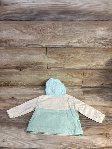 Baby mint and white hooded raincoat on wooden floor