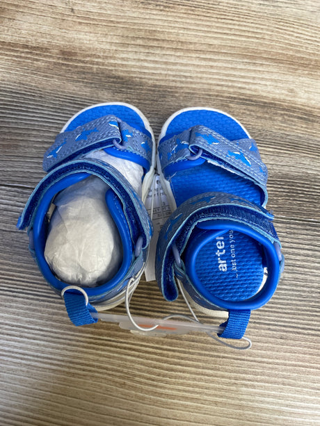 Blue toddler sandals with adjustable straps on wood floor, gently used kids footwear.