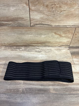 Flat lay of AZMed maternity back support band showing elastic ribbing and Velcro closure on woodgrain background