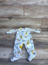 Top-down view of white footed blanket sleeper showcasing yellow giraffe and gray animal print on wood plank background