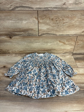 Flat lay of Mayoral ruffled velvet dress sz 12m showcasing ivory fabric with blue and tan floral print smocked bodice and long sleeves on wood floor