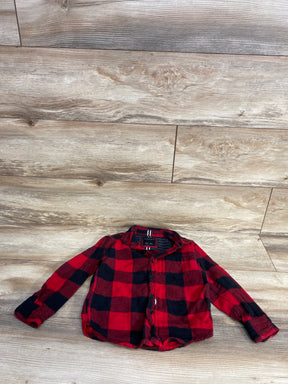 Red and black checkered flannel shirt with long sleeves on wooden floor background
