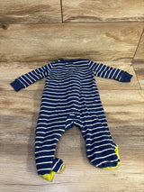 Flat lay of Carter's navy and white striped footed sleeper showcasing yellow feet on a wood plank background