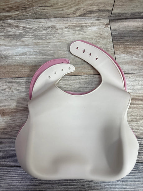 Two PandaEar silicone baby bibs with catch pockets in cream and pink on a wooden surface.