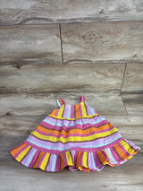Flat lay of 18-month muslin tank dress showing pink, yellow, orange and white horizontal stripes and ruffled hem on wood floor