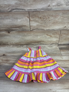 Flat lay of 18-month muslin tank dress showing pink, yellow, orange and white horizontal stripes and ruffled hem on wood floor