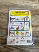 Wikki Stix Road Trip Bingo card with illustrations of cow, bus, motorcycle, airplane, and more on wooden surface
